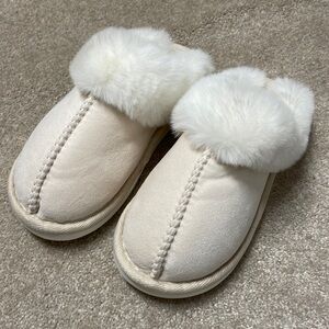 Beige and white similar UGG slippers